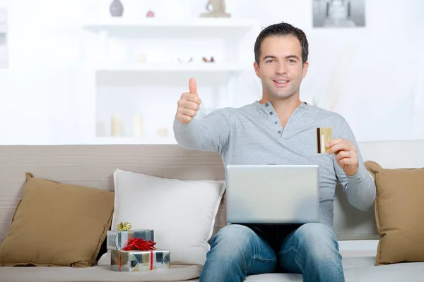 Glimlachende man met laptop en duimen omhoog — Stockfoto
