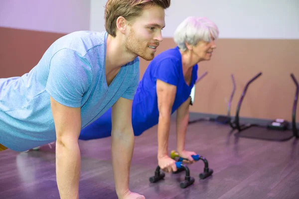 Mujer mayor haciendo push up para la terapia —  Fotos de Stock