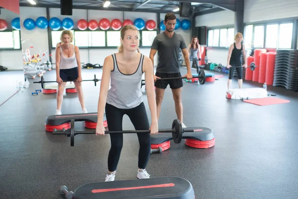 Grupo con barra de levantamiento de pesas en ejercicio crossfit — Foto de Stock