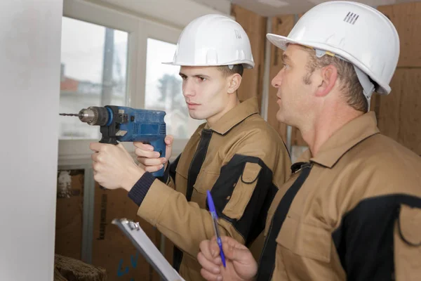 Lehrling bohrt in Wand — Stockfoto