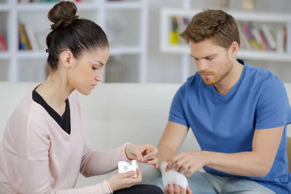 Helping boyfriend with damaged wrist — Stock Photo, Image