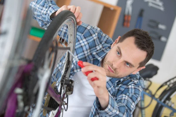 Homem inspecionando os pneus da bicicleta — Fotografia de Stock