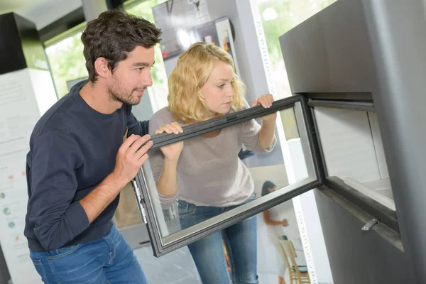 Paar kijken naar moderne houtkachel — Stockfoto