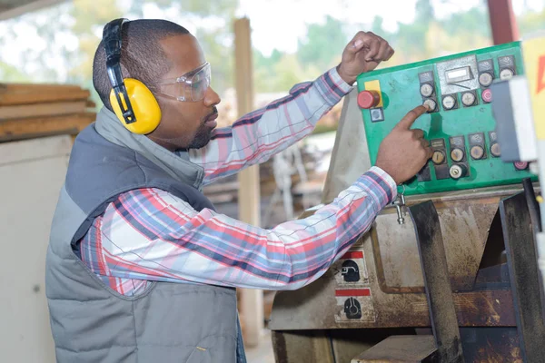 Людина з захистом вуха, що працює на заводі — стокове фото