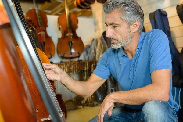 Homem olhando para violoncelo — Fotografia de Stock