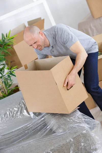 Hombre cansado con cajas de cartón alrededor — Foto de Stock