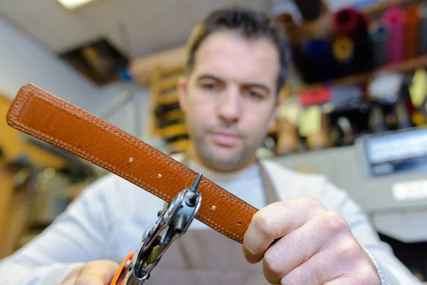 Hombre haciendo cinturones y cuero — Foto de Stock