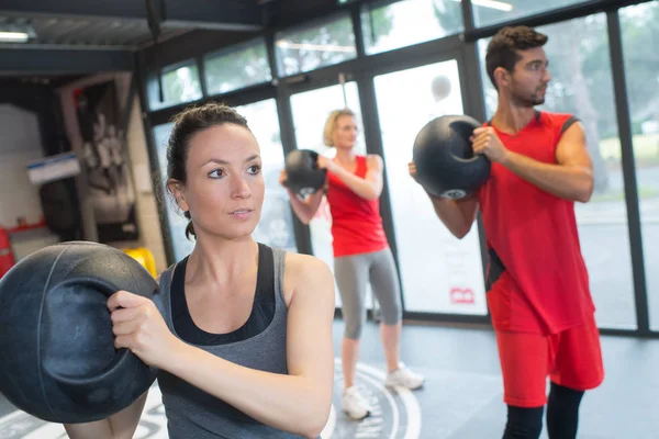 Pessoas em classe de fitness segurando suporte redondo — Fotografia de Stock