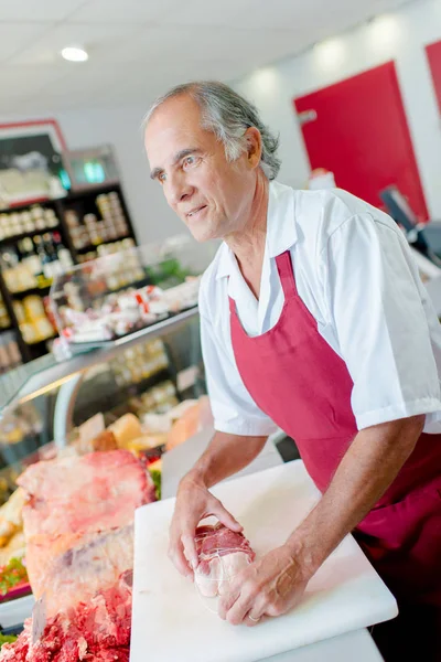 Carnicero sosteniendo junta de carne — Foto de Stock