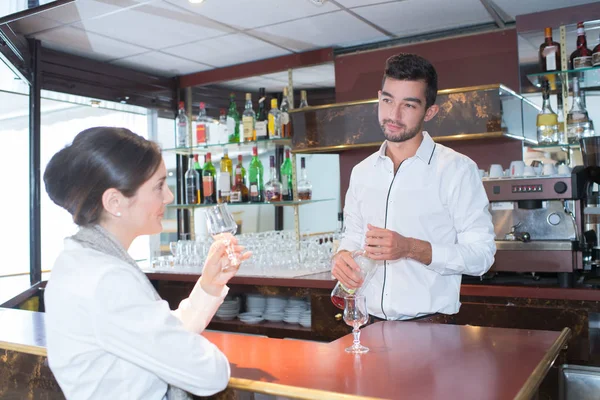 Meisje flirten met lachende jonge knappe barman — Stockfoto