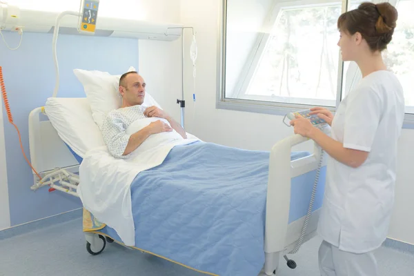 Krankenschwester besucht Patient in seinem Krankenhauszimmer — Stockfoto