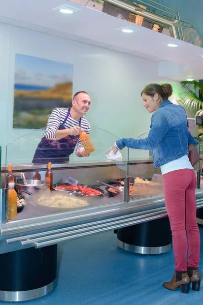 Woman being served at food counter — Stock Photo, Image