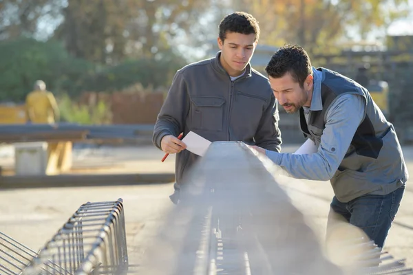 Arbeiter, die Metallstangen zählen — Stockfoto