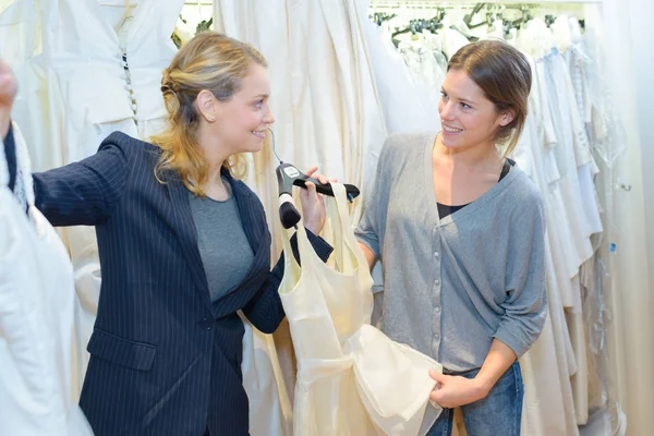 Mujer está eligiendo un vestido de novia en la tienda — Foto de Stock