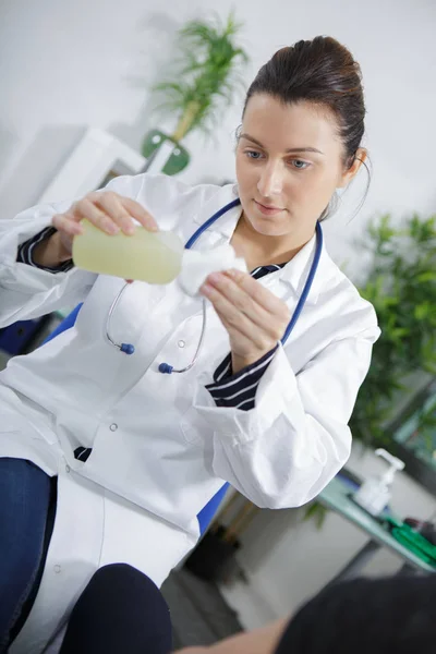 Female doctor disinfecting item — Stock Photo, Image