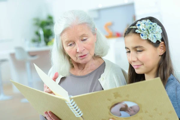 Mormor grand dotter titta på familjens fotoalbum — Stockfoto