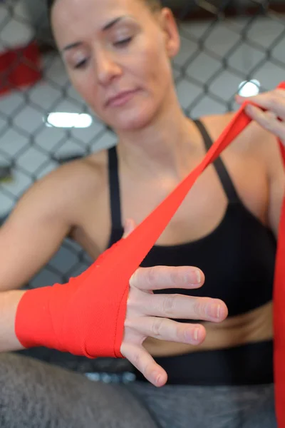 Vrouw is inwikkeling van handen met rode boksen hand wraps — Stockfoto