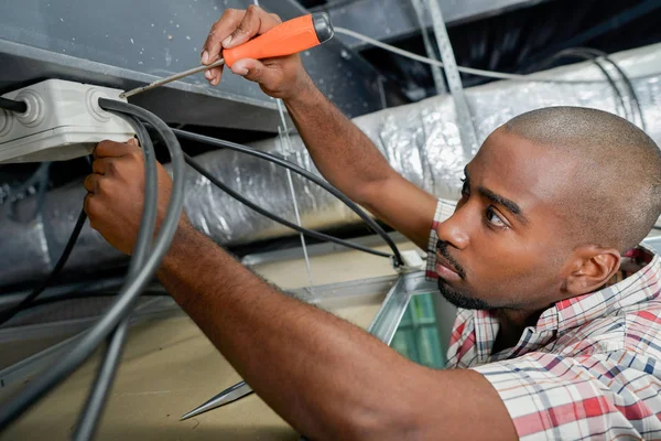 Elektriker arbeitet an Deckenverkabelung — Stockfoto