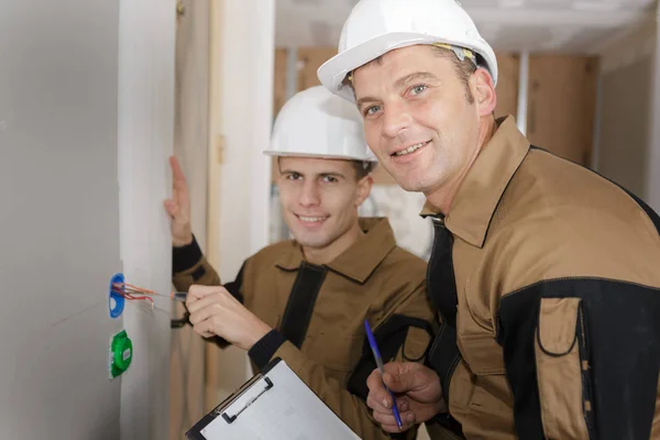 Два счастливых строителя и строители — стоковое фото
