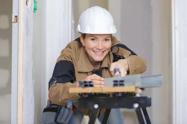 Kvinnlig builder polering plankan — Stockfoto