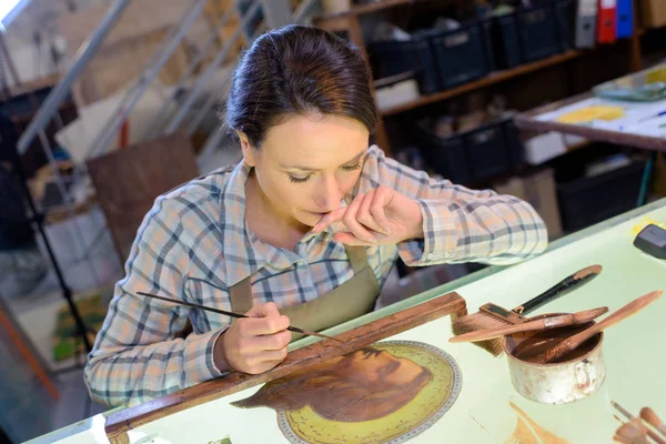 Porträt einer Kunsthandwerkerin, die religiöse Ikone in ihrer Werkstatt bemalt — Stockfoto