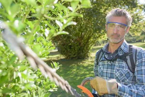 Homem segurando cortador de sebes — Fotografia de Stock