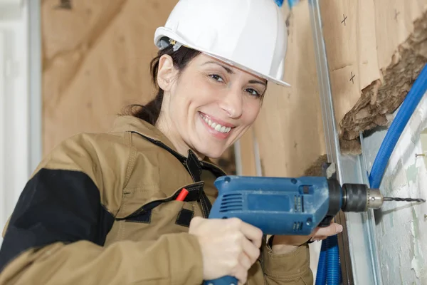 Donna intonaco perforazione del muro — Foto Stock