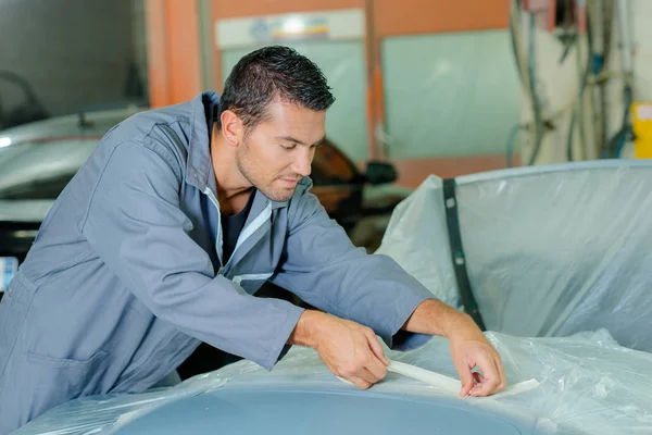 Mechanic applying masking tape — Stock Photo, Image
