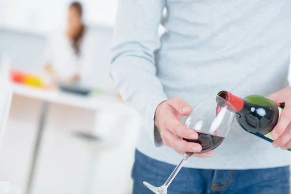 Homem derramando-se um copo de vinho tinto — Fotografia de Stock