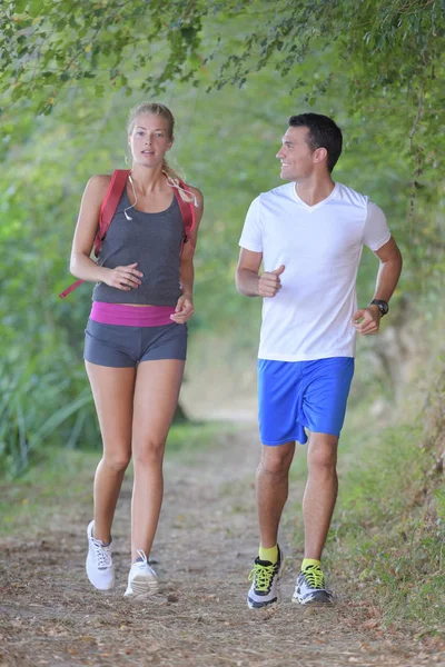 Pareja corriendo en el bosque — Foto de Stock