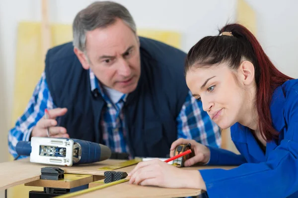 Young female worker using tape measure supervisor talking aggressively — Stock Photo, Image
