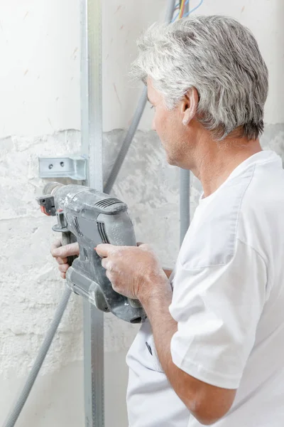 Maurer bohrt in eine Wand — Stockfoto