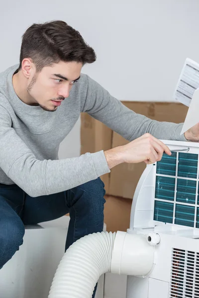 Male technician examining air conditioner — Stock Photo, Image
