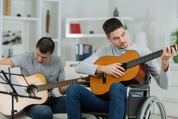 Man in rolstoel gitaarspelen met een vriend uitgeschakeld — Stockfoto