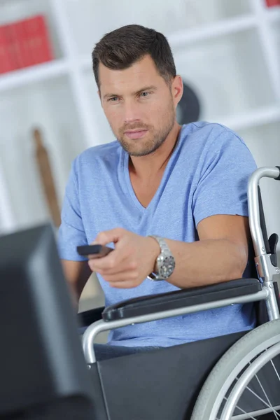 Handicapped man watching television in living room — Stock Photo, Image