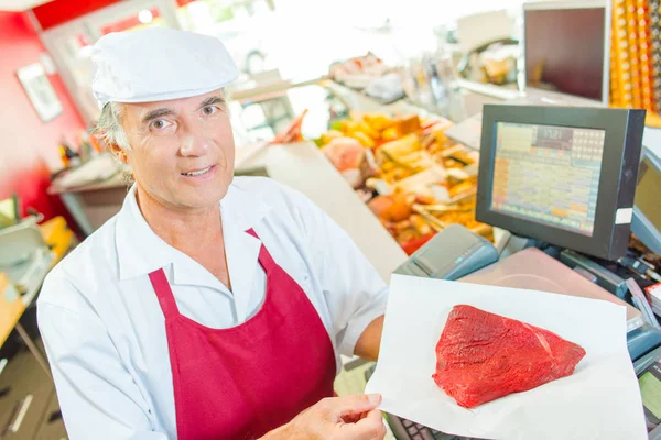 Butcher drží steak a steak — Stock fotografie