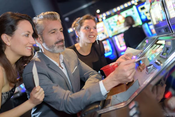 Две женщины и мужчина в казино — стоковое фото