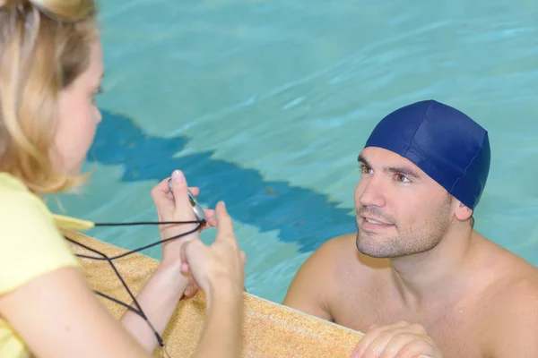 Nageur parlant à son entraîneur au bord de la piscine au centre de loisirs — Photo