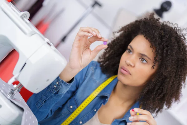 Fshion designer holding a set of threads and chooses one — Stock Photo, Image