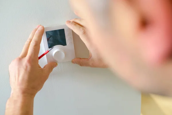 Elektriker montiert ein Thermostat — Stockfoto