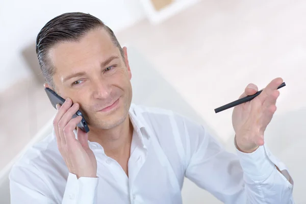 Guapo hombre de negocios hablando en el teléfono móvil y sonriendo — Foto de Stock