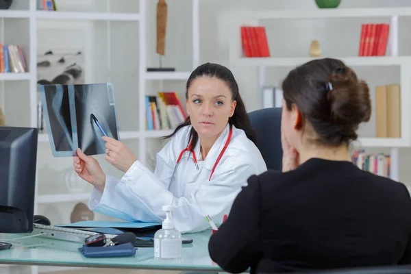 Женщина-врач смотрит на рентген в своем кабинете — стоковое фото