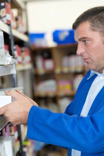 Arbetstagaren söker efter vissa små produkt — Stockfoto