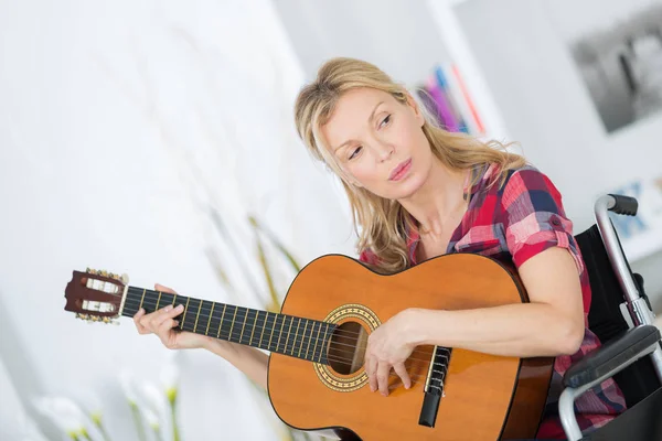 Lady nő zenész a kerekesszék gitározni otthon — Stock Fotó