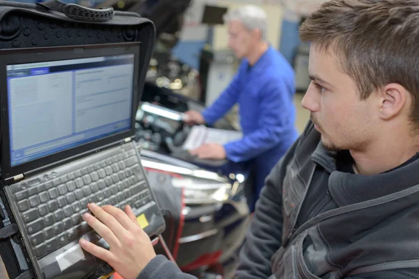 Professeur de mécanique automobile et stagiaire effectuant des tests à l'école de mécanique — Photo