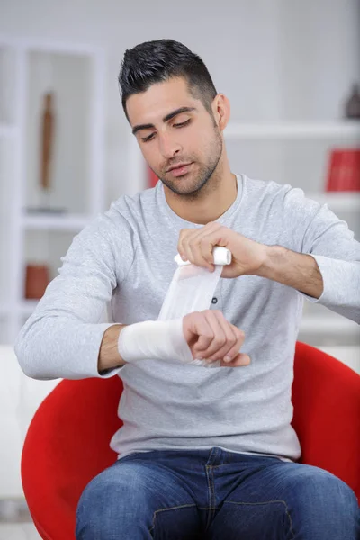 Homem bandagem seu pulso — Fotografia de Stock