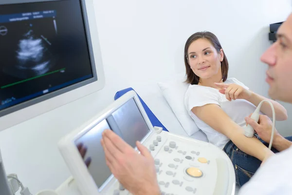 Mujer señalando a la imagen de ultrasonido de su brazo —  Fotos de Stock