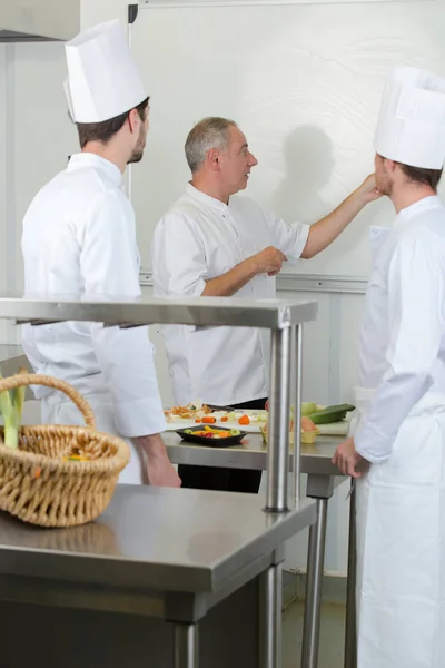 Seniorchef stand am Whiteboard, zwei Studenten hörten zu — Stockfoto