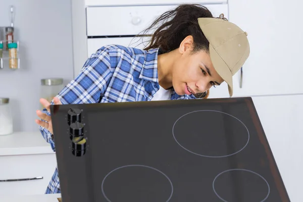 Female installing induction cooker — Stock Photo, Image