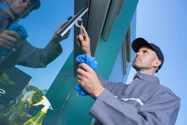 Hombre limpiando la ventana del edificio exterior — Foto de Stock